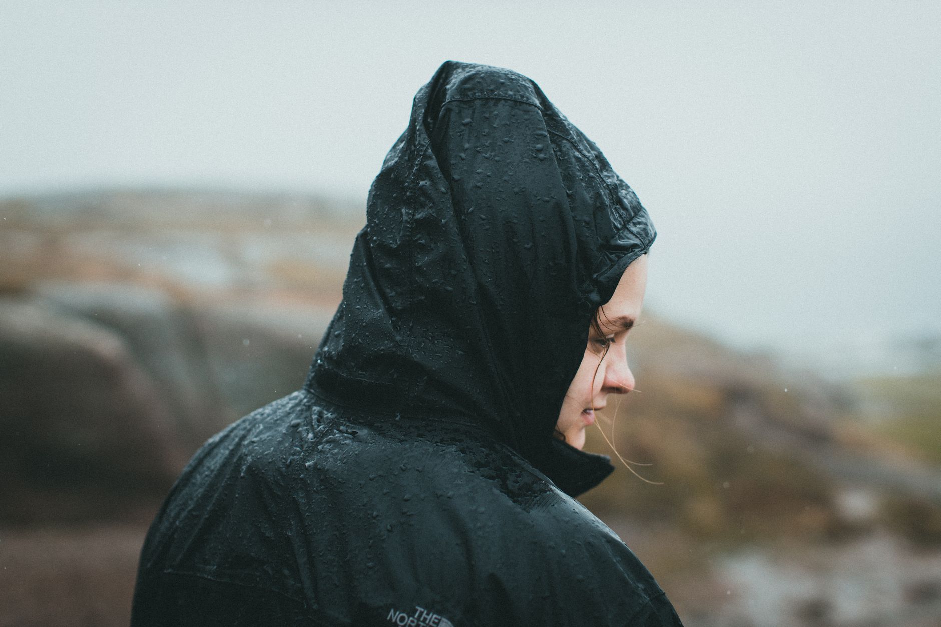 Une softshell portée en extérieur, avec une capuche réglable